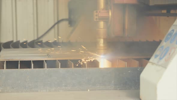 Plasma laser cutting metal plate in a factory alt