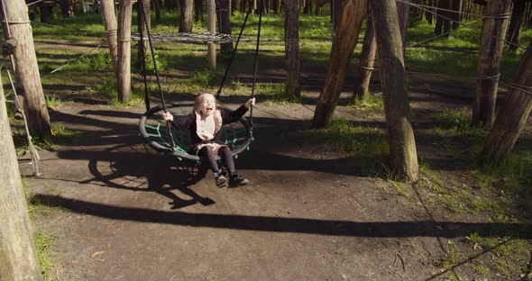 Little Girl Swinging On A Swing In The Recreation Park alt