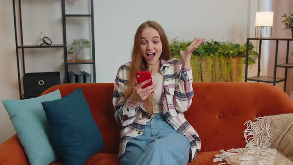 Young Adult Woman at Home Use Mobile Cell Phone Typing Browsing Say Wow Yes Found Out Great Big Win alt