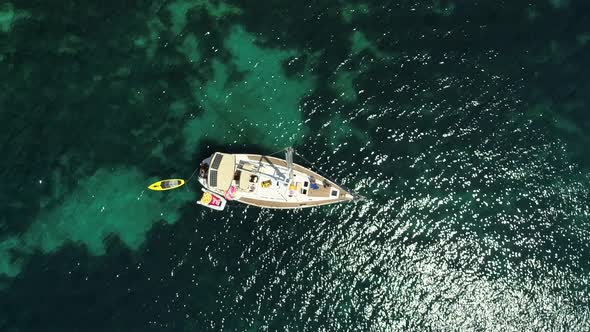 Aerial view above sailboat swinging on agitated waters in the coast of Greece. alt