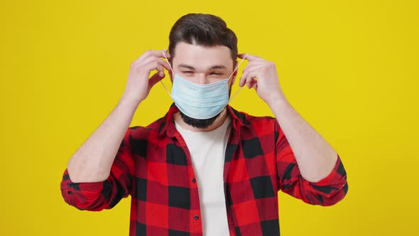 Closeup Portrait of a Young Man Wearing Protective Face Mask Isolated at the Yellow Background with alt