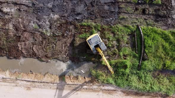 Aerial view fly away look down excavator alt
