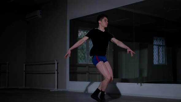 Concentrated Caucasian Young Man Performing Ballet Leaps Rehearsing in Studio Indoors alt