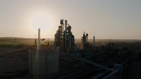Silhouette Cement Plant with High Factory Structure at Industrial Production Area at Sunset alt