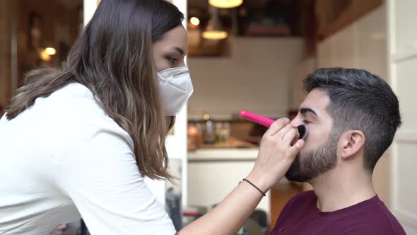Make-up artist wearing protective mask, applying make-up for wedding alt