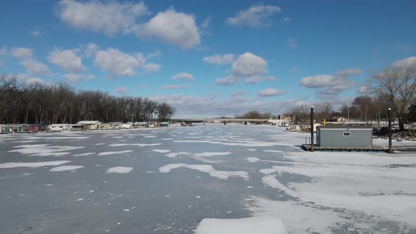 Drone view following the ice covered river in Wisconsin. Bright sunny day.