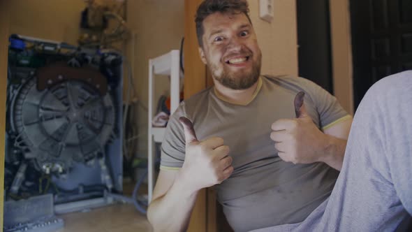 Man Rejoices That Repaired Washing Machine Shows Fingers Thumbs Up