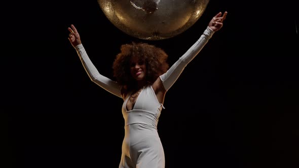 Charming African American Woman Enjoys Music and Dancing Under Shiny Disco Ball alt