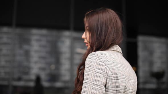 Gorgeous Girl with Long Hair Looking at Camera in the Wind