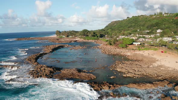 Low panning aerial shot of snorkelers and swimmers in Shark Cove on the North Shore of O'ahu, Hawaii alt