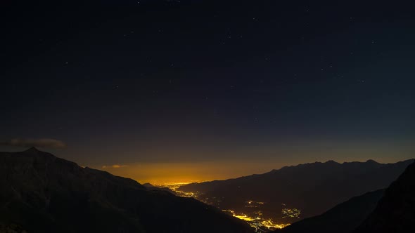 Time Lapse of the Milky way and the stars in summer night sky rotating over the Alps alt