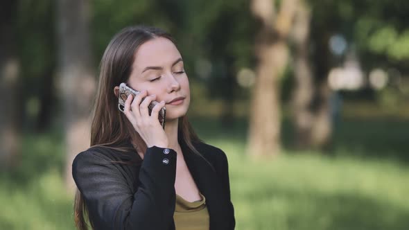 A Young Student Talking on the Phone in the Park alt