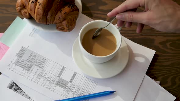 Business Planning Concept. Notepad, Pencil, Croissant and Coffee on a Wooden Background. alt