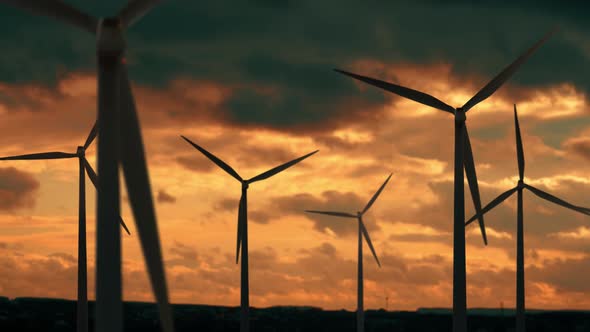Wind Turbines Farm at Beautiful Orange Sunset. Ecologic Energy Generators on Beautiful Sunny alt