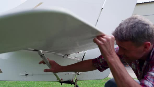 Aviator Checking Airplane Wings After Landing on Aerodrome alt