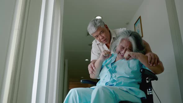 elderly woman with psychiatric symptoms is in a wheelchair with an elderly couple caring for her