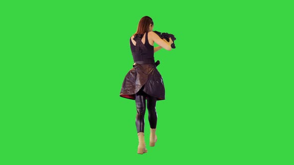 Cyberpunk Girl in Black Military Clothes Walks with Machine Gun Taking an Aim on a Green Screen