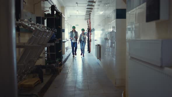 Factory Engineers Walking Production Facility alt