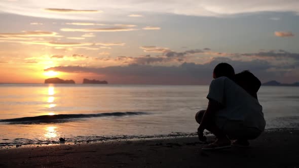 Rear view of a woman writing on the beach before sunset