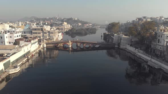 4k aerial footage of bridges spanning a water channel of the city of Udaipur, India. alt