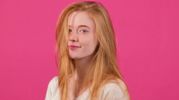 Pretty Young Red Haired Woman with Freckles Looking at Camera with a Smile alt