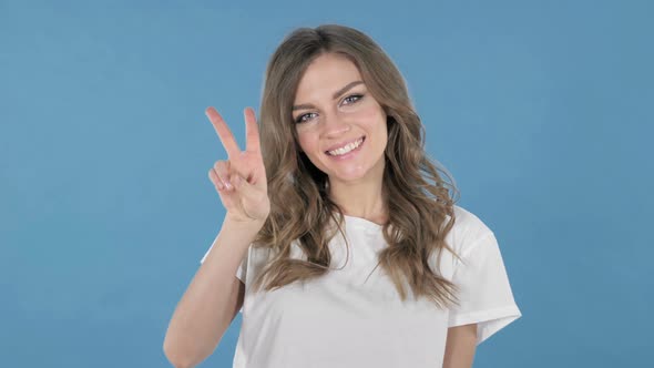 Victory Sign By Young Girl Isolated on Blue Background alt