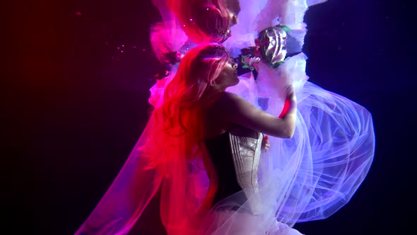 Girl Princess She Is Under the Water, She Is Illuminated By Pink Lighting, Her Dress and Hair Are alt