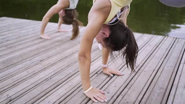 Sportswomen Do Exercises and Rest on Wooden Pier in Park