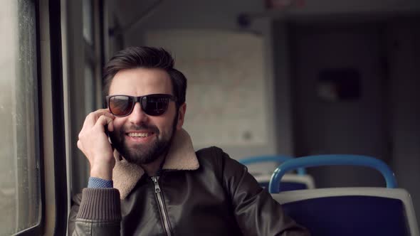 Man In Sunglasses Using Mobile Phone And Call To Friends. Man Talking On Smartphone In Train. alt