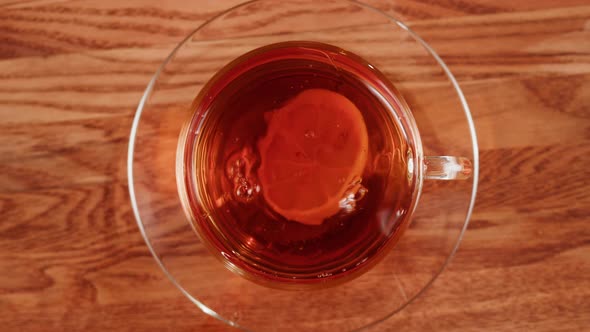 Putting Lemon Into Black Tea Top View alt