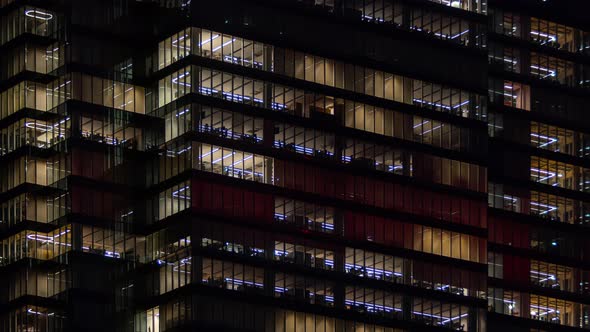 Time Lapse People Working Late Night Office Windows Light in Business Center Building Facade alt