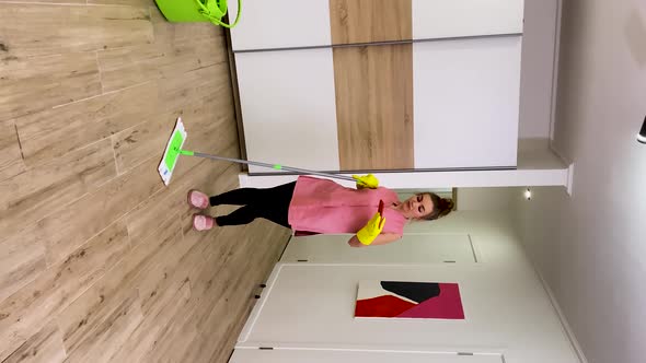 A Woman Washes the Floors Looking at the Phone Talks Oh My God Celebrating the Victory with the Good alt