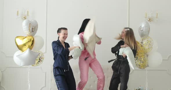 Three Girlfriends Having a Pillow Battle.