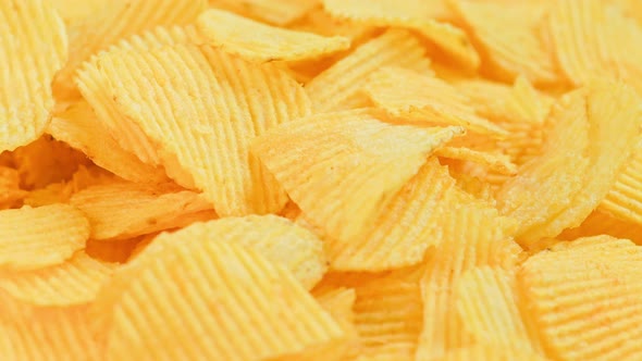 Looped Spinning Yellow Wavy Potato Chips Full Frame Closeup Background alt