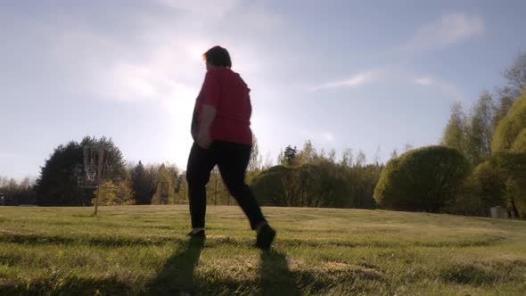 Idyllic Shot of a Middle Aged Lady Walking in a Park on a Sunny Day