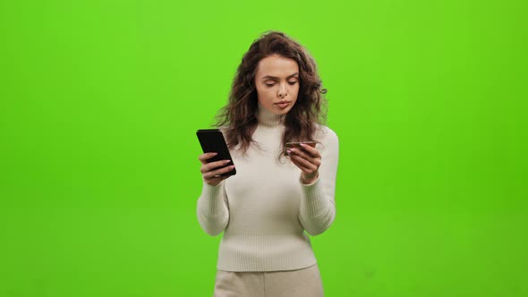 The Woman is Entering Her Bank Card Details Into Her Phone alt