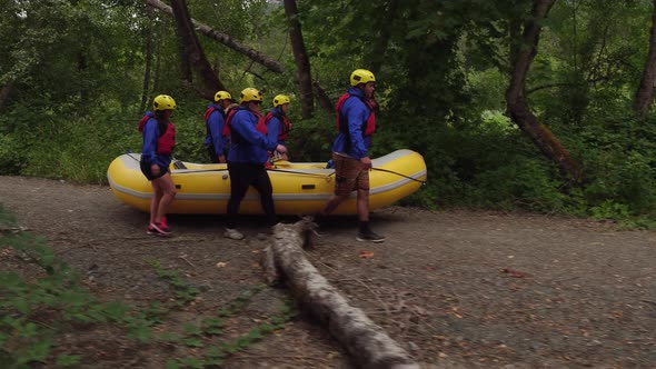 Group of people white water rafting carry raft together