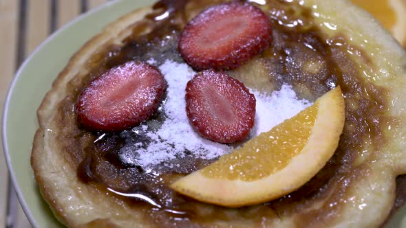 Pancake decorated with strawberry and orange