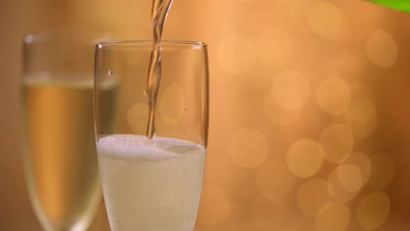 Champagne glasses over holiday bokeh blinking background, glasses with sparkling wine