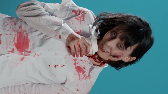 Vertical Video Creepy Looking Zombie with Deep Scars Smelling Coffee From a Cup on Blue Background alt