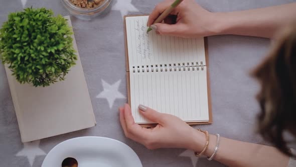 Young woman makes notes in her diary.