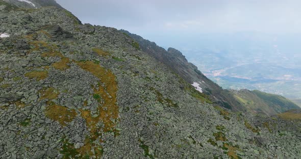 passing by mountain peak and appearing of snowy rocky slope with clouds alt