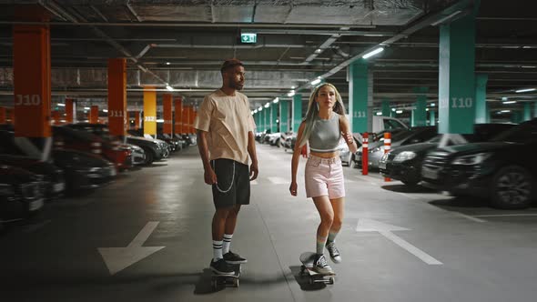 Young Woman and African American Guy with Colorful Dyed Hair Riding Skateboard at Underground alt