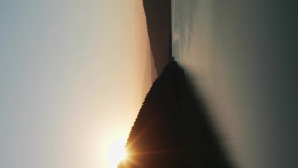 Vertical View Of Beautiful Frumoasa Dam In Harghita County, Romania With Sun Rising Behind Silhouett alt
