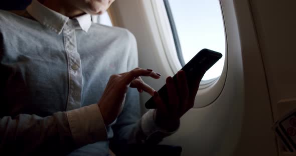 Amazing Shot of Young Relaxed Woman holding a Smartphone and Taking a Picture Through a Window alt