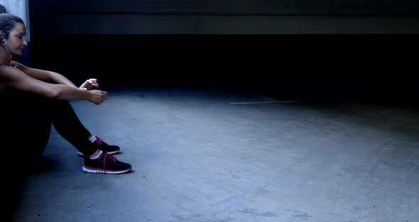 Woman taking break in underground parking area 4k alt