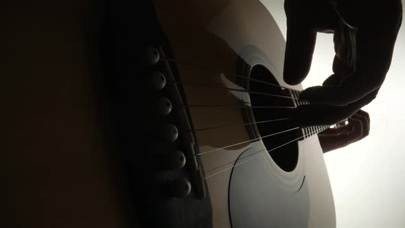 Low Angle View of Male Guitarist Playing Wooden Acoustic Guitar on White Background alt
