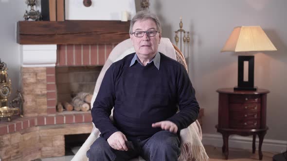 Portrait of Positive Senior Caucasian Man Keen on Soccer Watching Football Match on TV and Cheering alt