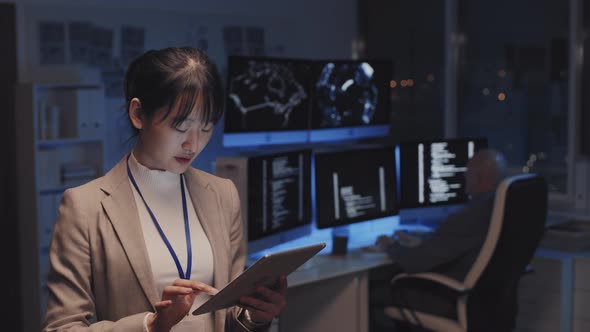 Asian Woman Using Tablet in Office alt