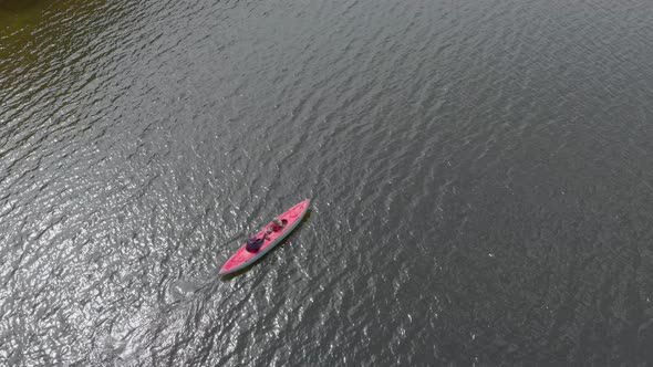 A Young Man and His Son Paddle in the Inflatable Kayak in a Sea or in a Lake alt
